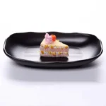 Black melamine dinner plates stacked elegantly on a wooden table