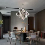 Smoky gray chandelier with glass bubbles hanging over a modern dining table