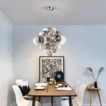 Smoky gray chandelier with glass bubbles hanging over a modern dining table