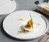 Elegant ceramic dinner plates arranged on a dining table with gold cutlery