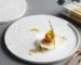 Elegant ceramic dinner plates arranged on a dining table with gold cutlery