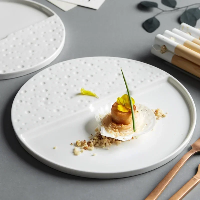 Elegant ceramic dinner plates arranged on a dining table with gold cutlery