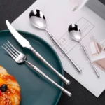 Matte gold flatware set with antique finish arranged on a wooden table