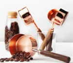 Set of stainless steel measuring cups with copper and rose gold finishes on wooden stand