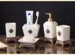 Soap dish in gold metallic ceramic, holding a white soap bar, with bathroom tiles in the background.