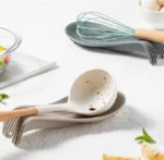 Silicone spoon rest holding a wooden spoon on a kitchen counter