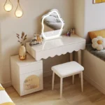 Modern makeup vanity desk with mirror and stool in a bedroom setting, showcasing ample storage and elegant design