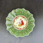 Christmas dinner plates with festive holly and berry pattern on a wooden table