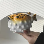 Creative pufferfish tiki mug for cocktails with vibrant hand-painted details on a wooden table