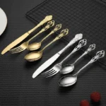 24-piece stainless steel cutlery set with gold handles displayed on a wooden table