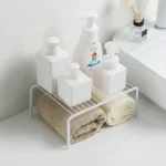 Adjustable dish drying rack with multiple tiers holding plates, bowls, and spice jars on a kitchen counter