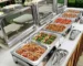 Commercial stainless steel electric food warmer with lid on buffet table
