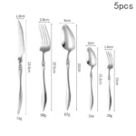 Elegant French stainless steel cutlery set with pointed tail handles on a wooden table