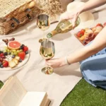 Set of 6 stainless steel wine glasses on a wooden table with red wine