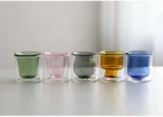Clear double wall insulated glass mug with espresso coffee on wooden table