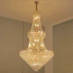 Modern crystal chandelier for dining room hanging over a wooden table with warm glow