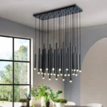 Modern gold pendant light with clear glass shade hanging over a wooden dining table.