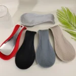 Silicone spoon rest holding a wooden spoon on a kitchen counter