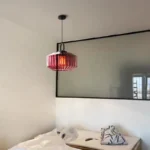 Modern colored glass pendant lamp illuminating a cozy dining room with vibrant hues