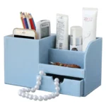 Office desktop storage box with pen holder and remote slots, viewed from above.