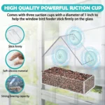 Transparent window bird feeder attached to glass with suction cups, filled with seeds, attracting a cardinal