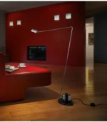 Italian design replica black floor lamp, shown in a living room with a fireplace.