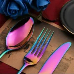Gold flatware set with spoon, fork, and steak knife on a white tablecloth