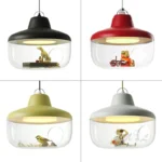 Black metal and glass pendant light hanging low over a bedside table, minimalist bedroom style