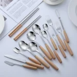 Stainless steel flatware set with wooden handles displayed on a table