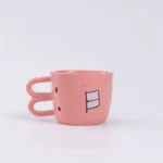 Funny pig teapot pouring tea from its snout on a kitchen counter