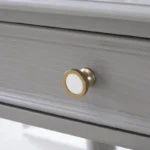 Modern white dressing table with mirror and stool in a bedroom setting