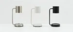 Three-quarter angle showing the lamp's metallic sheen and simple silhouette on a desk.