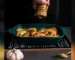 Ceramic bread baking pan with golden crust loaf on cooling rack