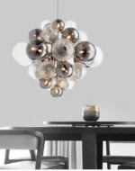 Smoky gray chandelier with glass bubbles hanging over a modern dining table