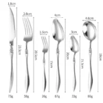 Elegant French stainless steel cutlery set with pointed tail handles on a wooden table