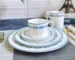 Elegant bone china dinner set with plates and bowls on a wooden table
