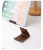2-in-1 Solid Wood Phone Stand - Black Walnut Business Card Display Rack for Home Office Desk Decor – in a cozy room setting