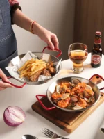 Stainless steel paella pan with double ears on a stove