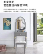 Modern white dressing table with mirror and stool in a bedroom setting