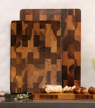 Acacia wood cutting board with fresh fruits and vegetables on a kitchen counter