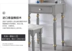 Modern white dressing table with mirror and stool in a bedroom setting