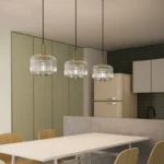 Close-up of the glass pendant light, highlighting the clear glass texture and brass metal accents.