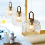 Nordic LED hanging light fixture with a frosted glass globe, illuminating a cozy living room corner.