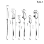 Elegant French stainless steel cutlery set with pointed tail handles on a wooden table