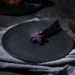 Hexagonal dinner plate with Japanese-inspired ceramic design on a wooden table