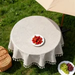 Round linen tablecloth with tassels on a dining table