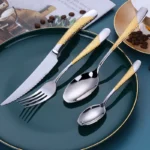 Elegant gold flatware set with steak knife, fork, and spoon on a dark table