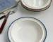 Set of four Korean rice bowls with blue stripe pattern on white ceramic
