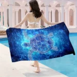Blue star turtle quick dry beach towel on sand with ocean background