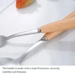 Stainless steel flatware set with wooden handles displayed on a table